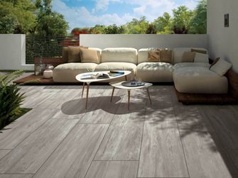 Terrasse moderne avec jardin attenant. Plaques de terrasse en optique bois