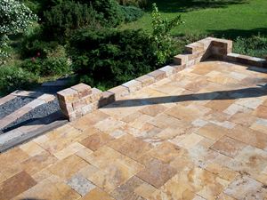 Dalles en travertin Gold en format opus romain, muret en pierre naturelle et jardin