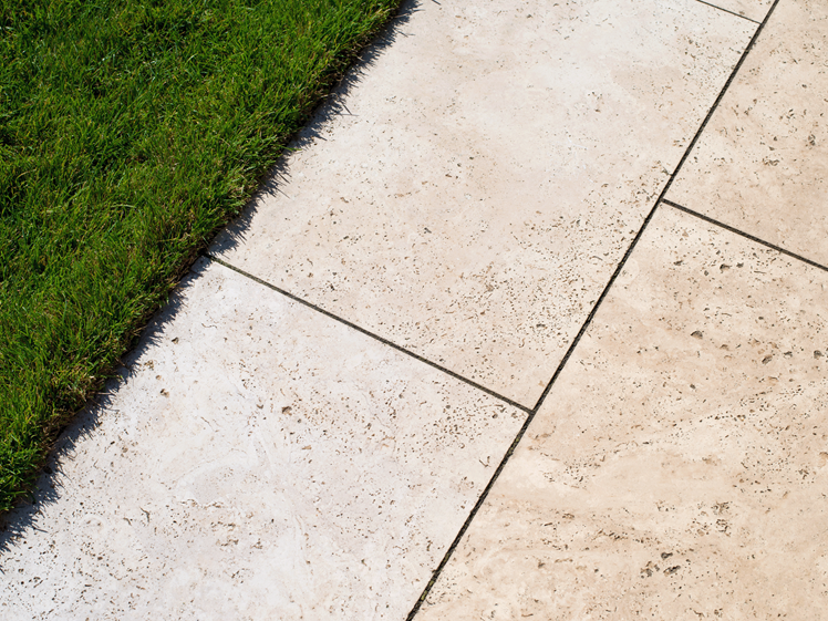 Le travertin Medium Line sur la terrasse avec deux bouteilles décoratives colorées