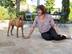 Une femme est assise avec son chien sur le dallage en travertin Noce posé sur sa terrasse