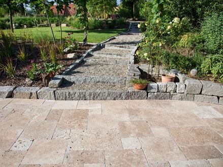 Terrasse en travertin Noce en premier plan, murets en granite, jardin en arrière plan