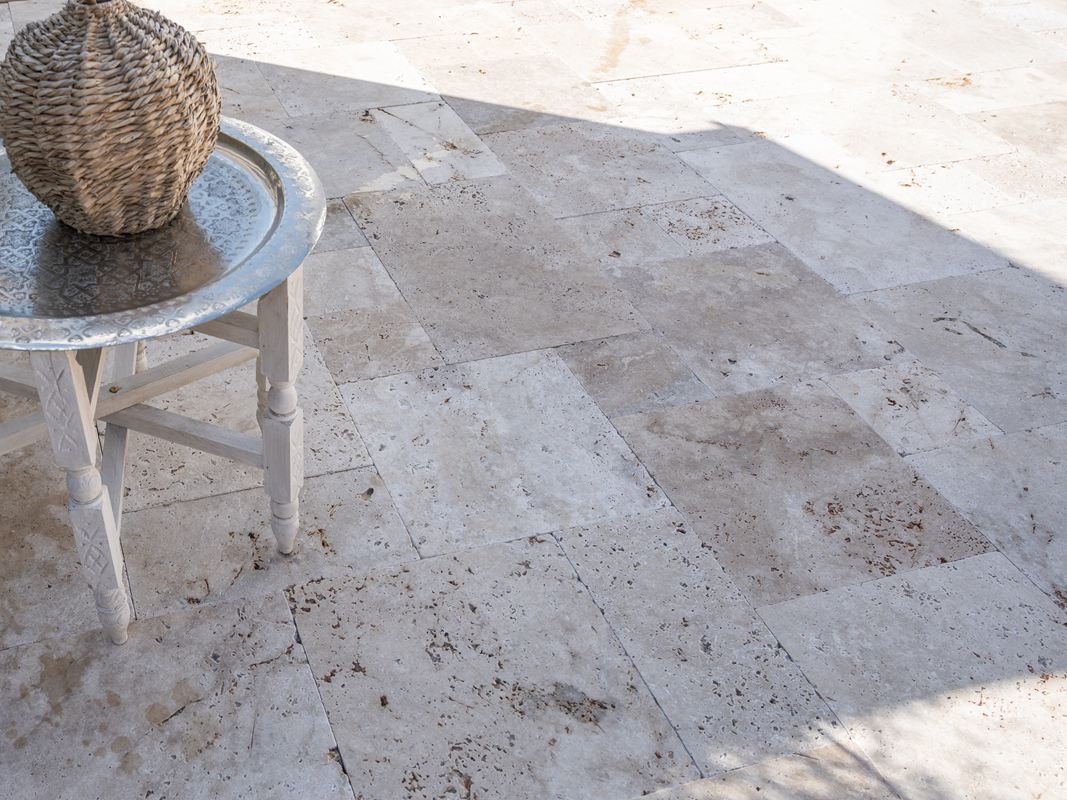 Dalles de terrasse en travertin Rustic, vue sur une partie de la terrasse, pilliers blancs en arrière plan
