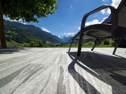 Terrasse avec dalles de granit Urban Grey Line et chaise longue avec vue sur les Alpes