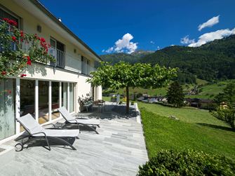 Terrasse avec dalles de granit, solariums et montagnes à l'arrière-plan