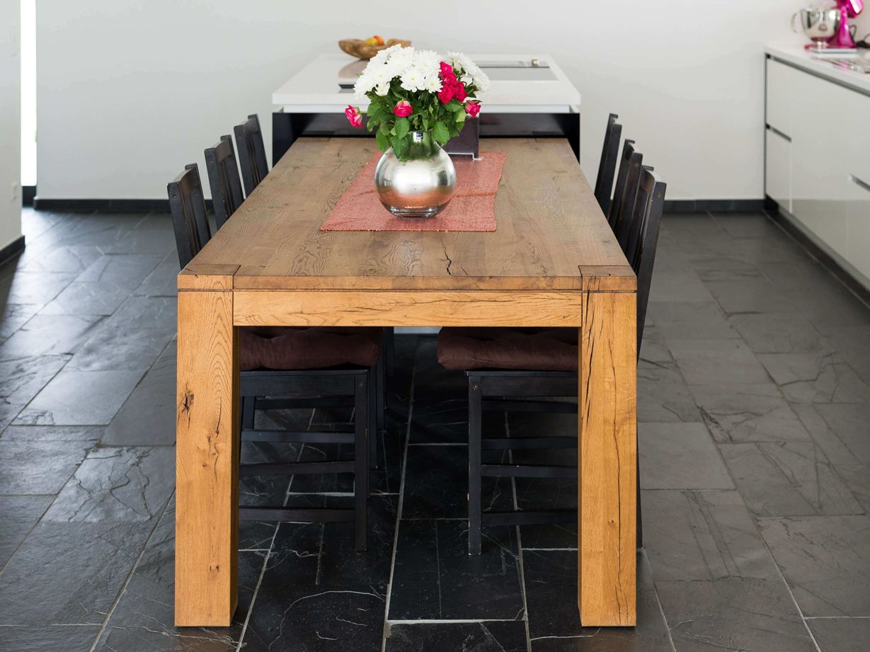 Une table en bois qui réchauffe l'ardoise noire Carrelage en ardoise Black Rustic, table en bois et murs blancs