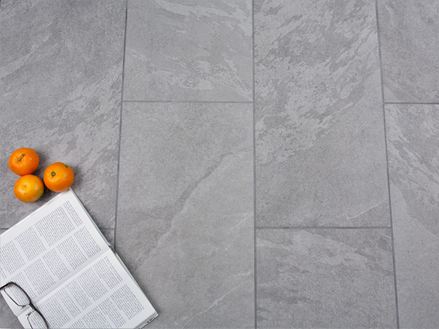 Des oranges et un livre sur le revêtement en grès cérame imitation ardoise