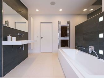 Baignoire sur carreaux de calcaire clair et ardoise comme revêtement mural