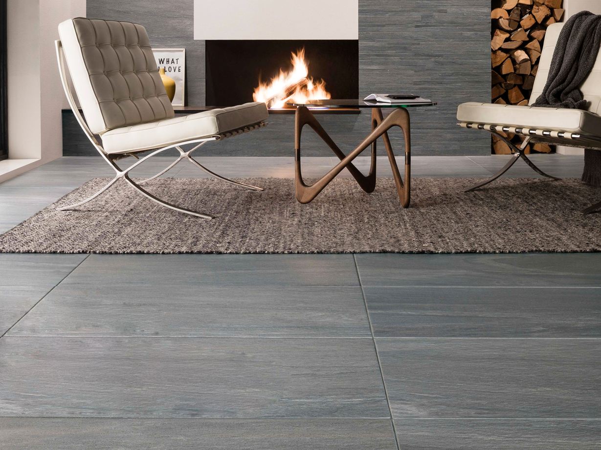 Un salon naturel et moderne grâce à Mountain Grey  La soirée idéale : lire au coin du feu sur un carrelage effet pierre Mountain Grey.