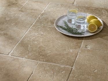 Vue de près sur le carrelage en travertin Classic Country et un plateau posé sur le sol