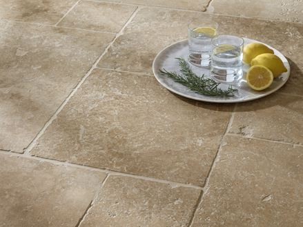 Vue de près sur le carrelage en travertin Classic Country et un plateau posé sur le sol