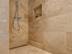Une douche entièrement recouverte de carreaux en travertin Ivory Classic