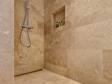 Une douche entièrement recouverte de carreaux en travertin Ivory Classic