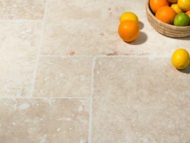 Une corbeille de fruits posée sur le carrelage Ivory Cream en travertin