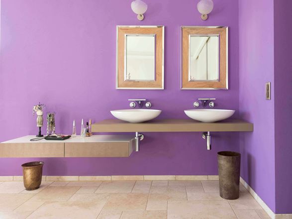 Salle de bain avec mur violet et deux miroirs, sol en carrelage en travertin Light à la finition vieillie