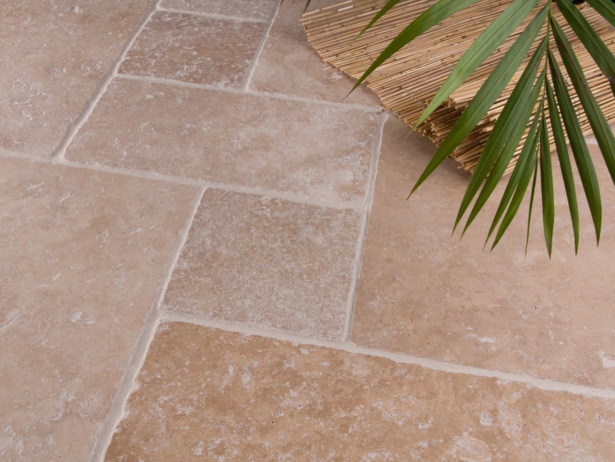 Rustique et naturel : le travertin Medium Le carrelage en travertin Medium en format opus romain et un palmier