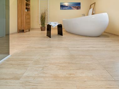 Le carrelage en travertin Natura dans une salle de bain avec baignoire