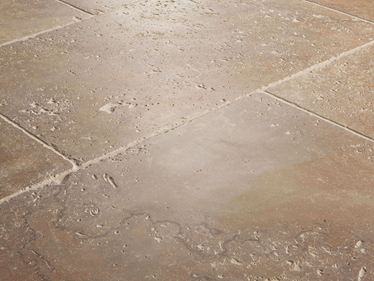 Gros plan sur le carrelage en travertin Noce