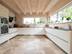 Le sol en travertin Rustic dans une cuisine blanche de style moderne