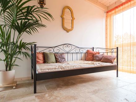 Chambre avec lit, plante et travertin rustique au sol