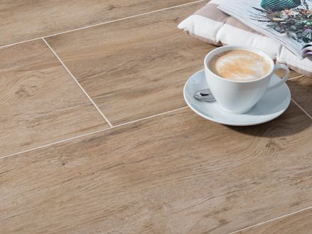 L'apparence authentique du carrelage imitation bois Woodline Beige et une tasse de café