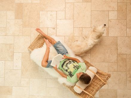 Un garçon sur une chaise longue sur un sol en travertin posé en opus romain