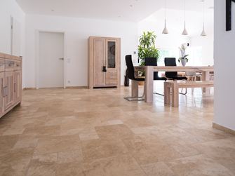 Une salle à manger en travertin Medium avec une table et des chaises