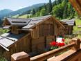 Vue des montagnes et autres chalets depuis un chalet en bois dans les Alpes suisses