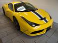 Une Ferrari jaune garée en biais sur le sol en grès
