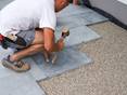 une homme sur la gauche qui pose sur un nid de gravillons la pierre naturelle