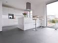 L'ardoise combinée à des surfaces claires laquées. La cuisine blanche avec des éléments en métal sur en sol en ardoise Grey Slate