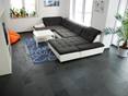 Sa teinte anthracite est moderne et élégante. Salon avec canapé noir et blanc et carrelage d'ardoise Mustang comme revêtement de sol par le haut