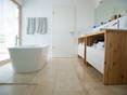 Le travertin se marie bien avec un mobilier en bois. salle de bain baignoire