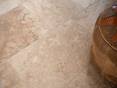 Les joints clairs rendent le carrelage homogène. En détail : carrelage Rustic, en travertin tambouriné, à droite un pouf marocain