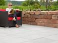 femme assise sur un fauteil sur terrasse en pierre calcaire