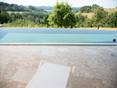 Se détendre sur du travertin au bord de la piscine. premier plan transat blanc et derrière grande piscine