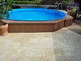 Une belle piscine bleue devant un sol en travertin Medium