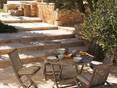 Terrasse avec revêtement de sol en travertin et meubles de terrasse en bois mi-ombragé
