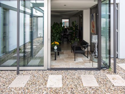 Blick von Travertin Rustic Terrasse in den stilvollen Wintergarten