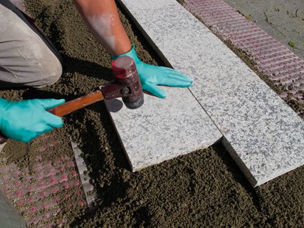 Les dalles sont posées au mortier sur une couche de base en gravier.