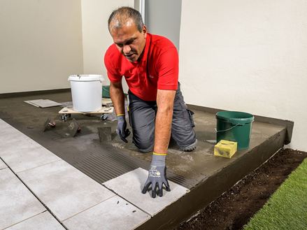Un carreleur pose des dalles en grès cérame