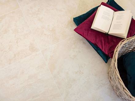 Des carreaux en effet travertin avec des coussins et un livre ouvert